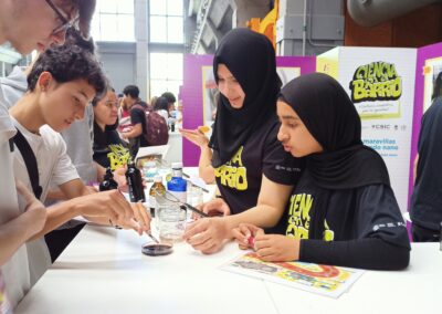 Alumnas del IES Barri Besòs explicando su taller en la V Feria de Ciencia en el Barrio en Madrid.